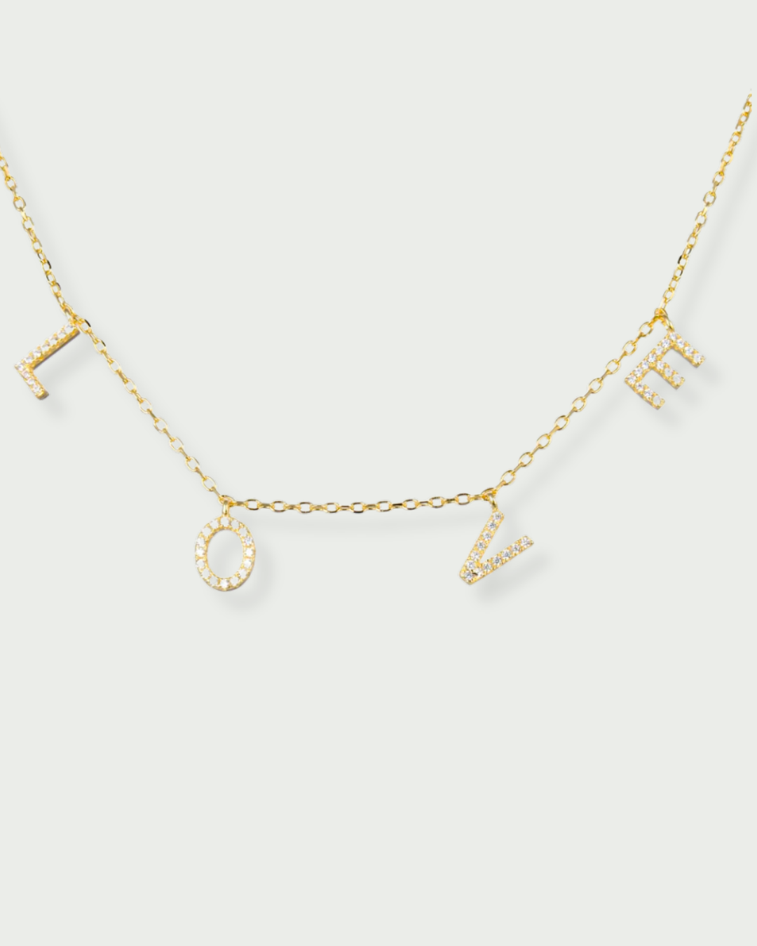Collier « Love » en argent 925 doré à l’or fin 18 carats, pendentif composé de lettres serties de zirconiums formant le mot LOVE, suspendu à une chaîne fine, finition polie brillante.