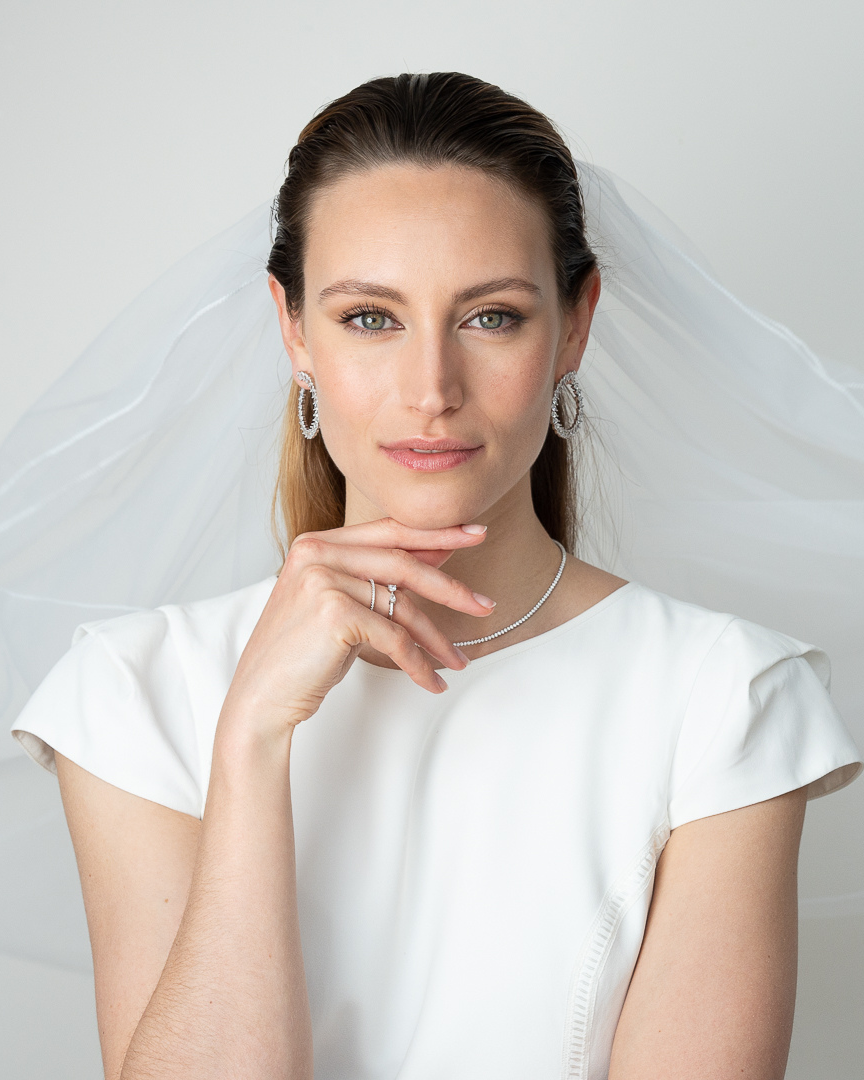 Boucles d’oreilles « Créoles Éclat ‑ Blanc » en argent 925 rhodié, créoles plates revisitées composées d’un délicat assemblage de mini‑zirconiums taille poire, finition polie brillante. 
