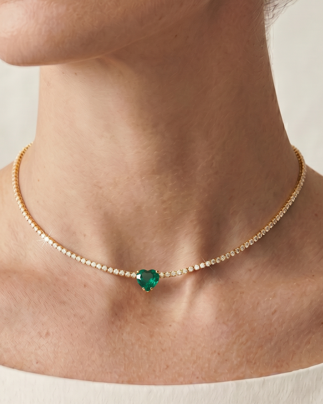 Choker Tennis Cœur Vert en argent 925 doré à l’or jaune 18 carats, composé d’une rivière de zirconiums blancs et orné d’un zirconium vert en forme de cœur.
