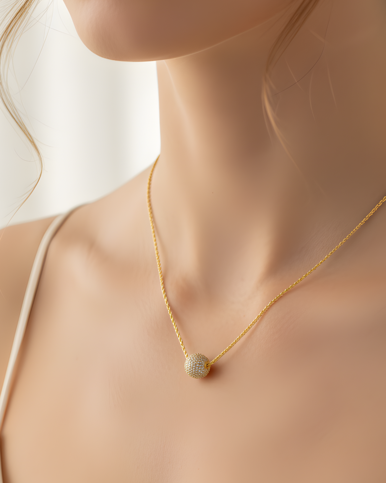 Collier « Atlas » en argent 925 doré à l'or 18 carats jaune, pendentif composé d’une boule pavée de zirconiums blancs, chaine torsadée.