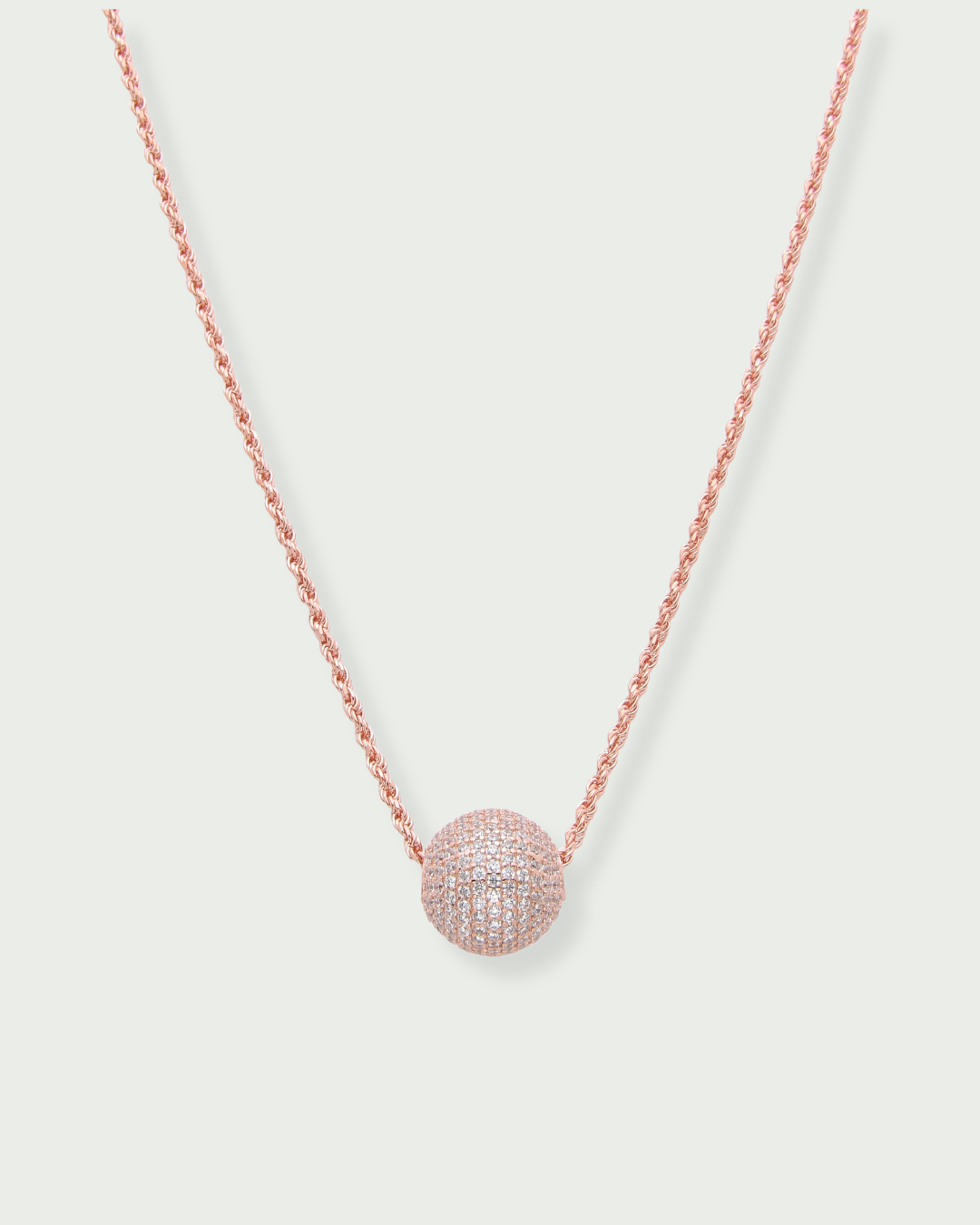 Collier « Atlas » en argent 925 doré à l'or rose 18 carats, pendentif composé d’une boule pavée de zirconiums blancs, chaine torsadée.