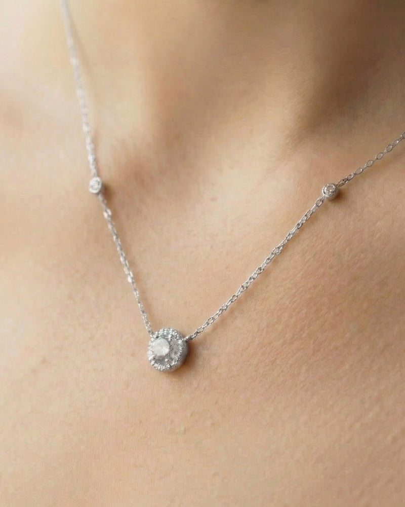 Collier « Collier Infini Rond ‑ Blanc » en argent 925 rhodié, pendentif rond orné d’une pierre zirconium centrale taille brillant, chaîne 40 cm (+6 cm réglable), finition polie brillante.