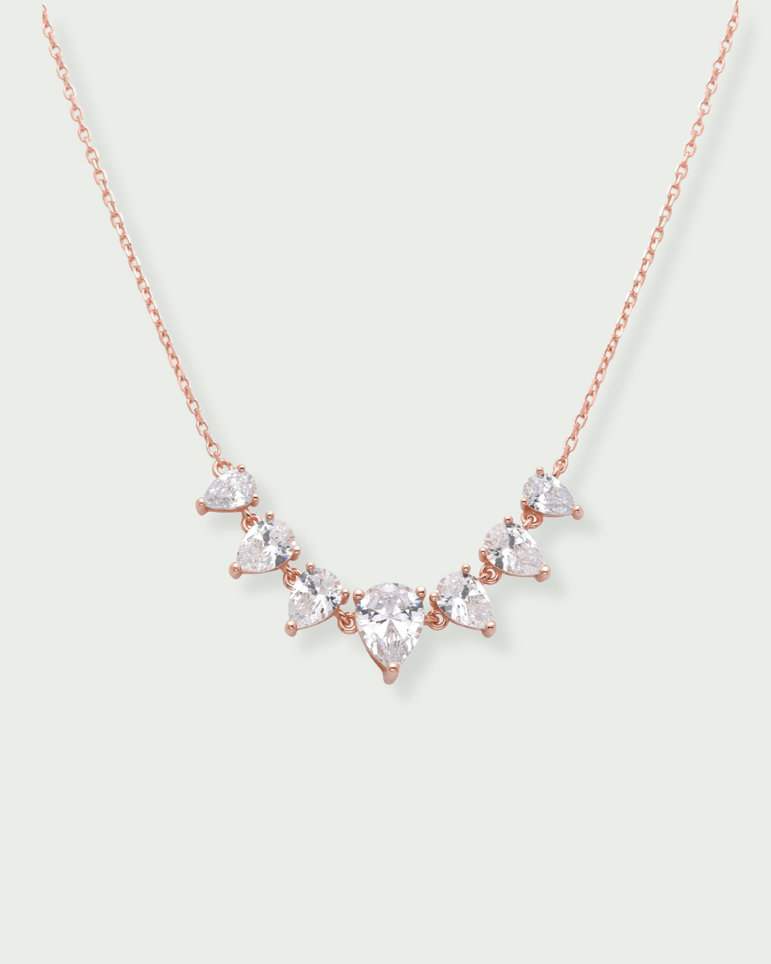 Collier « Éclats de Poire » en argent 925 doré à l'or rose 18 carats, alternance de pierres blanches taille poire montées sur une chaîne fine, finition polie brillante.