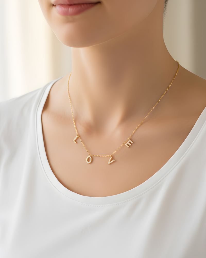 Collier « Love » en argent 925 doré à l’or fin 18 carats, pendentif composé de lettres serties de zirconiums formant le mot LOVE, suspendu à une chaîne fine, finition polie brillante.