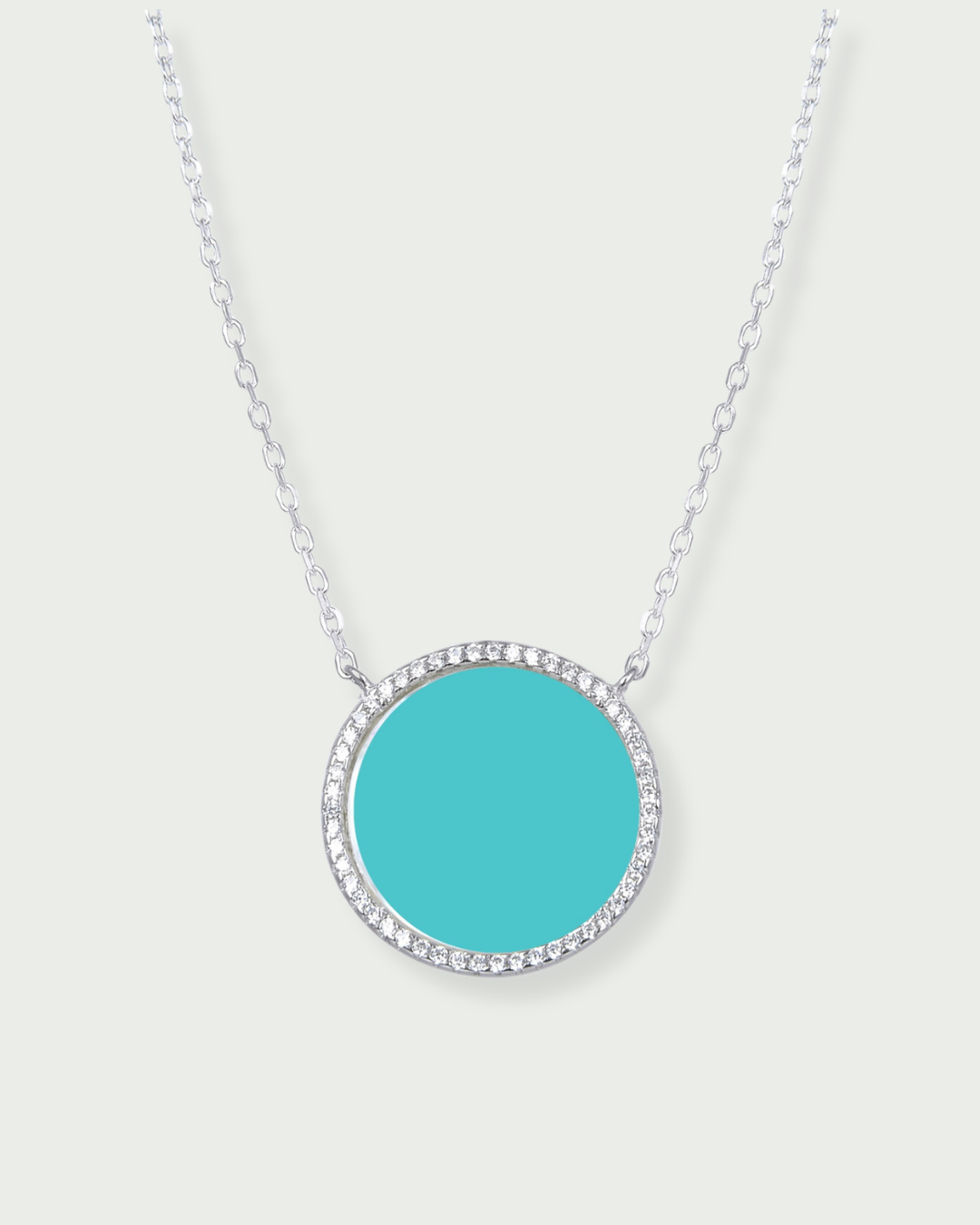 Collier en argent 925 rhodié, orné d’une grosse médaille ronde sertie d’une pierre turquoise, finition polie brillante.