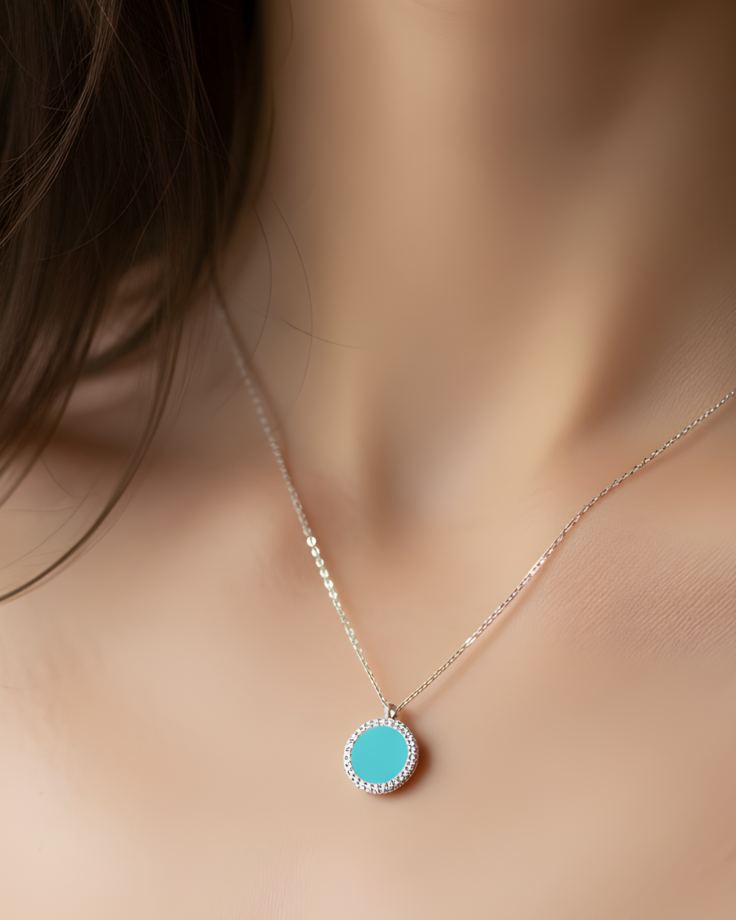 Collier en argent 925 rhodié, orné d’une petite médaille ronde sertie d’une pierre turquoise, finition polie brillante.