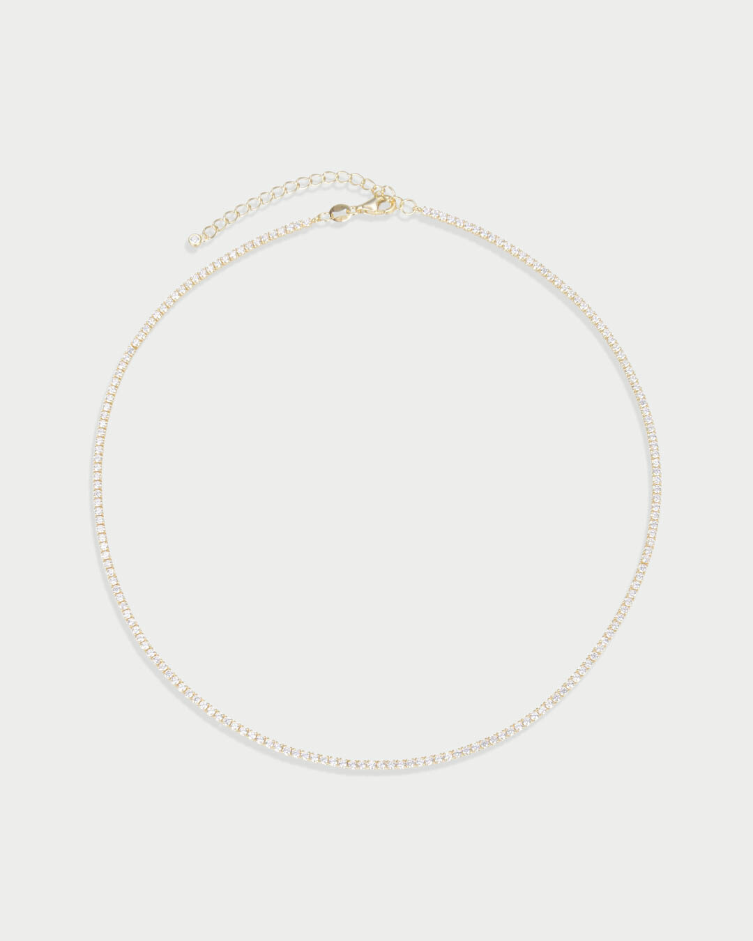 Collier Tennis Intemporel – Doré en argent 925 doré à l’or 18 carats, ligne continue de pierres délicatement serties pour un éclat uniforme et raffiné, finition lumineuse résistante à l’oxydation, fermoir sécurisé, conçu pour sublimer le décolleté.