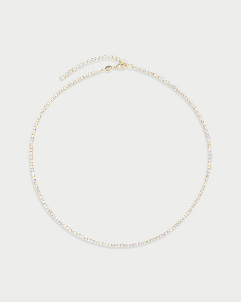 Collier Tennis Intemporel – Doré en argent 925 doré à l’or 18 carats, ligne continue de pierres délicatement serties pour un éclat uniforme et raffiné, finition lumineuse résistante à l’oxydation, fermoir sécurisé, conçu pour sublimer le décolleté.