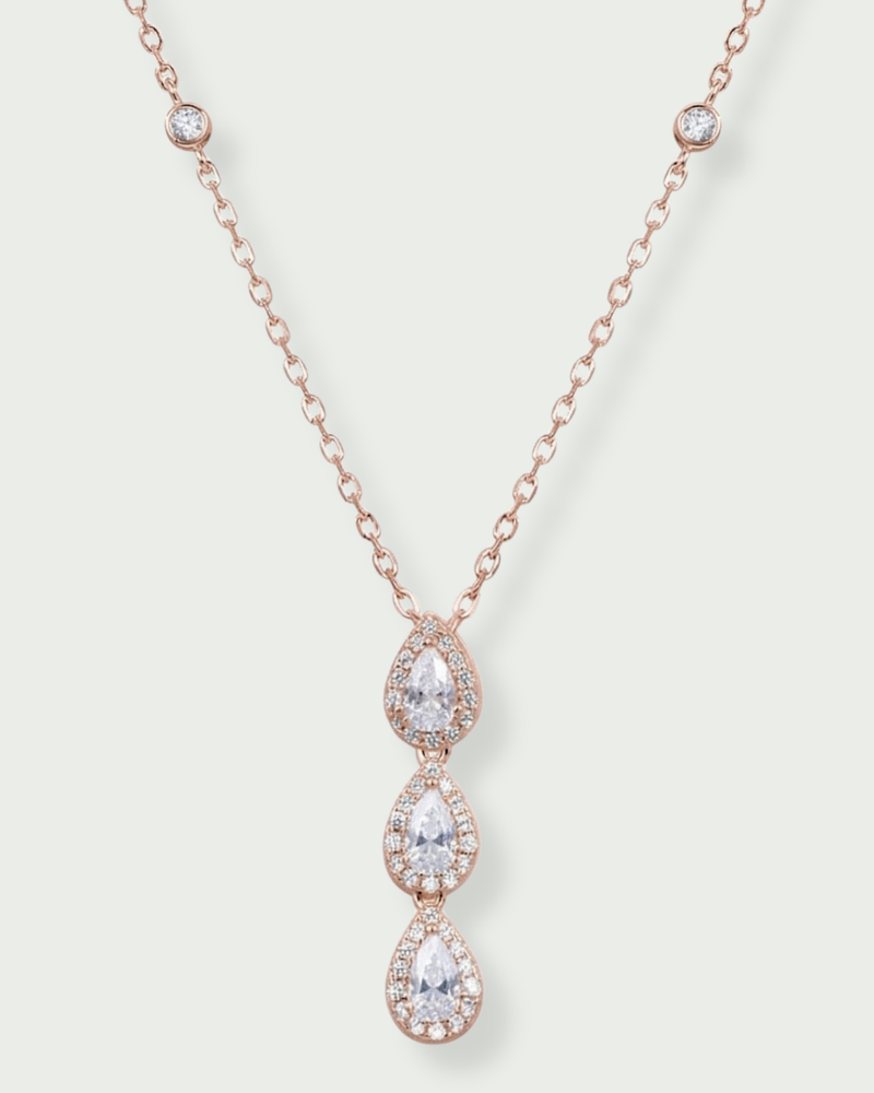Collier Trois Poires Pavées en argent 925 millièmes doré à l’or rose 18 carats, composé de trois motifs taille poire en zirconium blanc, délicatement pavés et suspendus en cascade. Chaîne fine et élégante, longueur 38 + 5 cm ajustable, motif central de 25 mm, finition polie brillante.