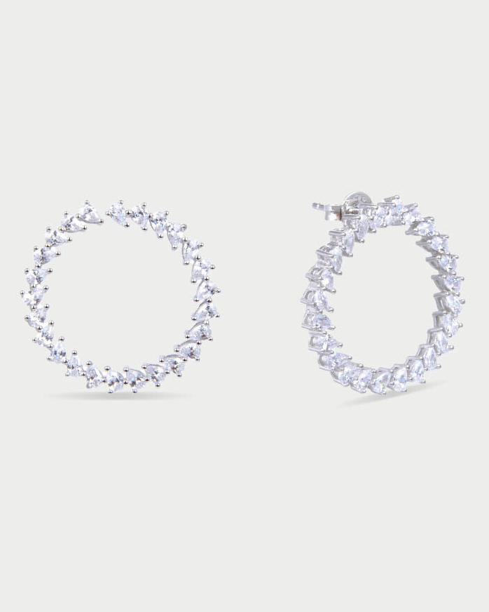 Boucles d’oreilles « Créoles Éclat ‑ Blanc » en argent 925 rhodié, créoles plates revisitées composées d’un délicat assemblage de mini‑zirconiums taille poire, finition polie brillante. 
