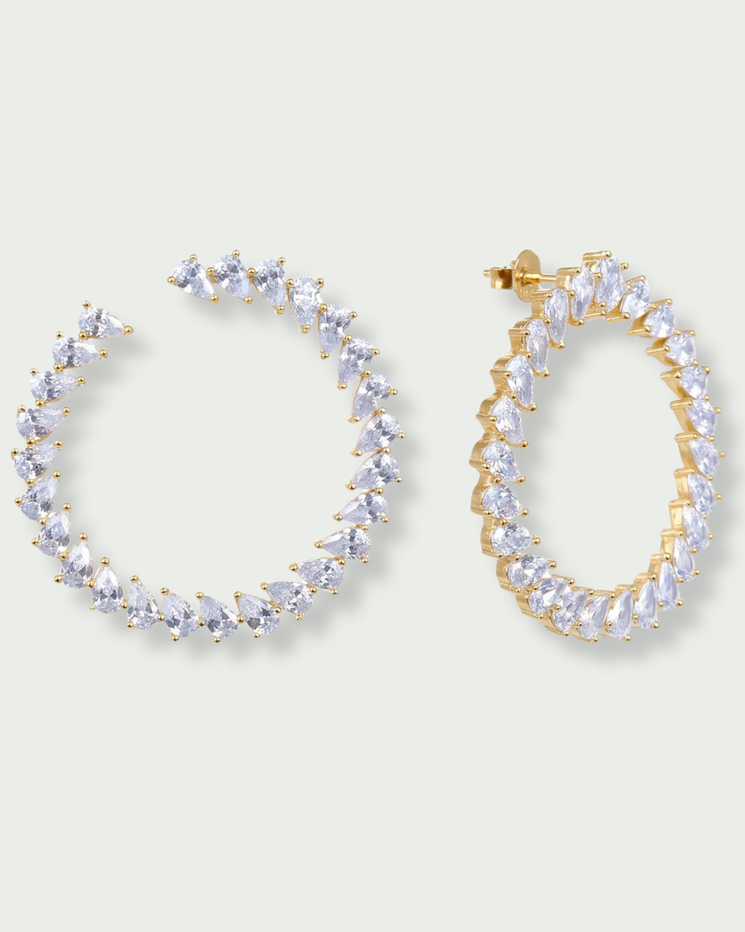 Boucles d’oreilles « Créoles Éclat ‑ Blanc » en argent 925 rhodié, créoles plates revisitées composées d’un délicat assemblage de mini‑zirconiums taille poire, finition polie brillante. 
