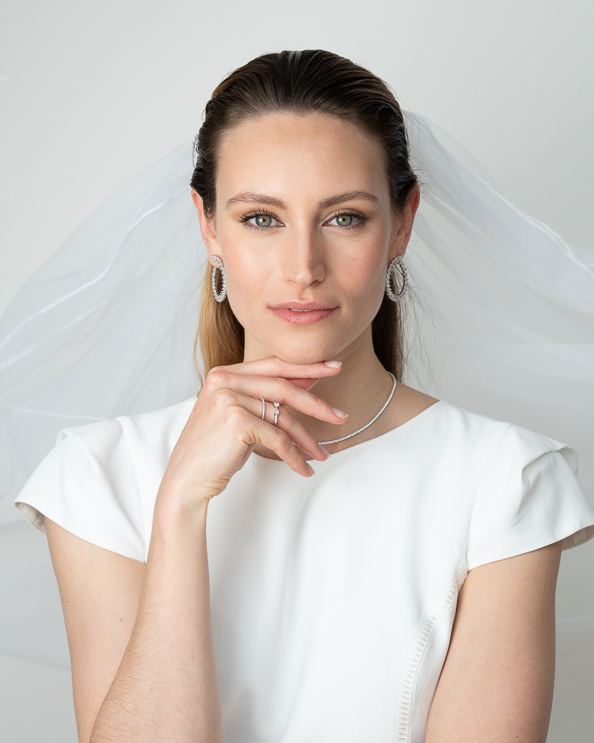 Boucles d’oreilles « Créoles Éclat ‑ Blanc » en argent 925 rhodié, créoles plates revisitées composées d’un délicat assemblage de mini‑zirconiums taille poire, finition polie brillante. 
