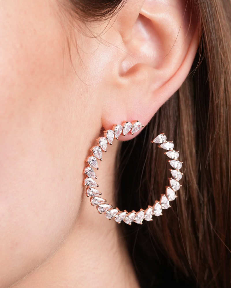 Boucles d’oreilles « Créoles Éclat ‑ Blanc » en argent 925 rhodié, créoles plates revisitées composées d’un délicat assemblage de mini‑zirconiums taille poire, finition polie brillante. 
