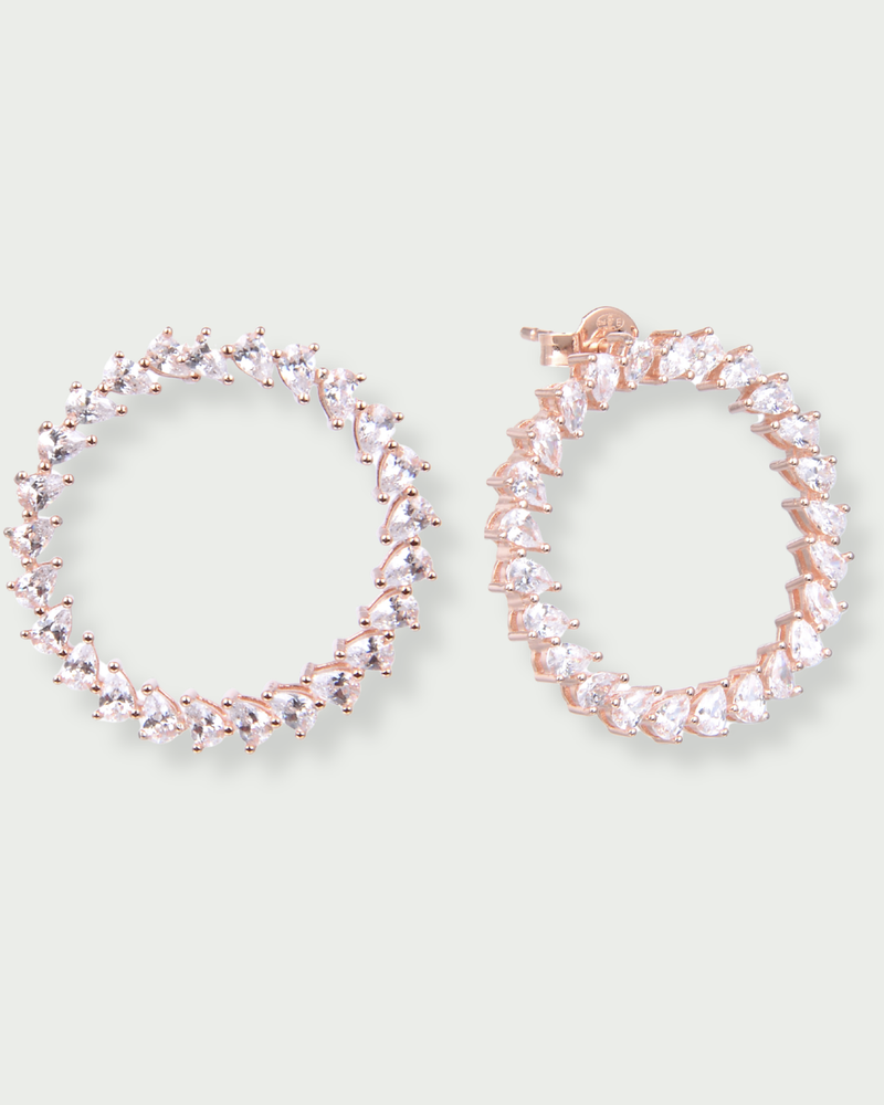 Boucles d’oreilles « Créoles Éclat ‑ Blanc » en argent 925 rhodié, créoles plates revisitées composées d’un délicat assemblage de mini‑zirconiums taille poire, finition polie brillante. 
