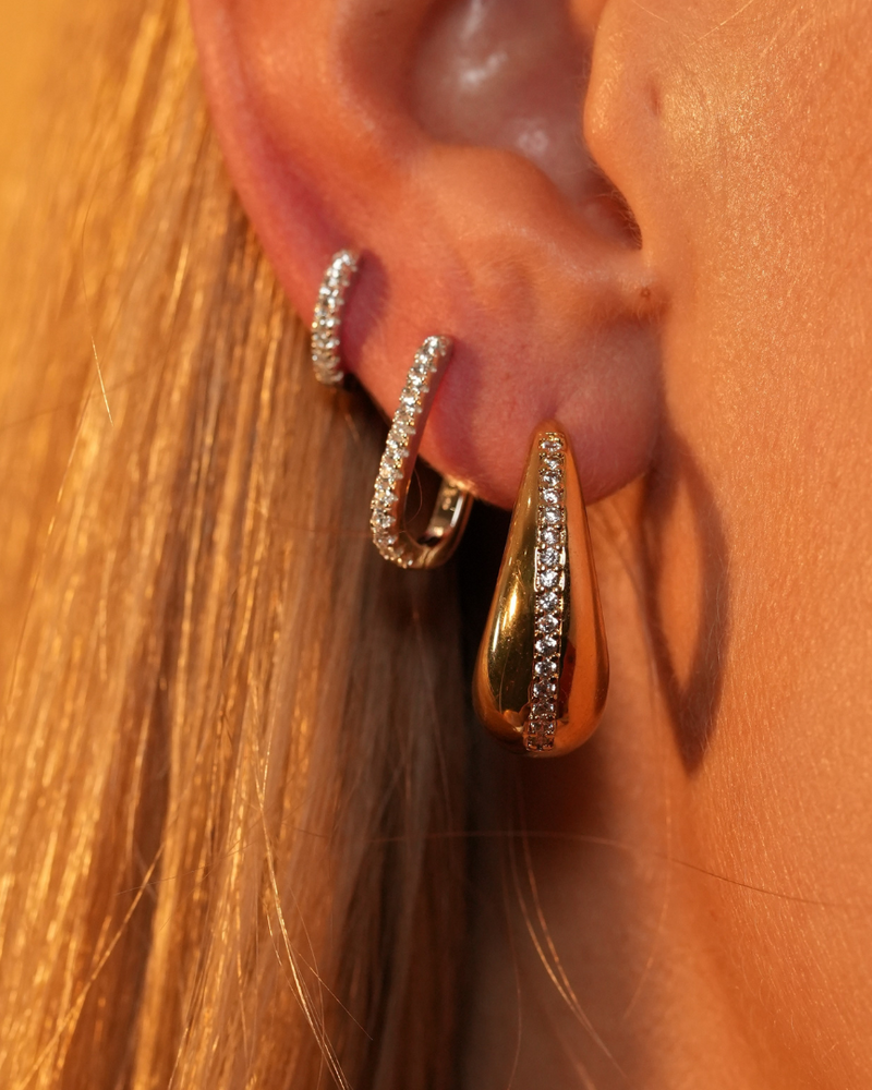 Créoles Pavées Intemporel M – Doré en argent 925 doré à l’or 18 carats, créoles de taille moyenne délicatement pavées de pierres, finition lumineuse résistante à l’oxydation, fermoir sécurisé, éclat solaire et élégant au quotidien.
