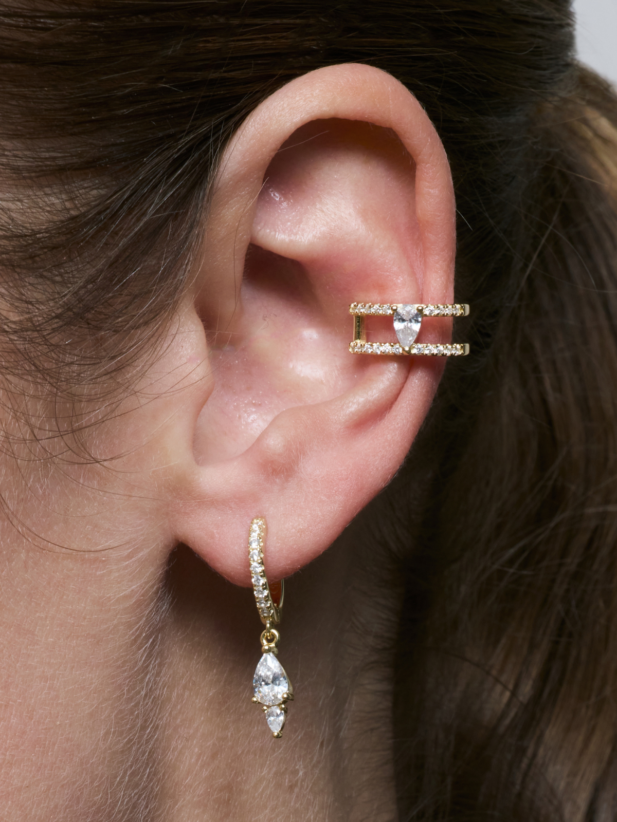 
Earcuff Signature doré en argent 925 plaqué or 18 carats, design double anneau ouvert orné d’un zirconium taille poire et d’un pavage de pierres, bijou d’oreille élégant qui épouse délicatement l’oreille sans perçage supplémentaire.