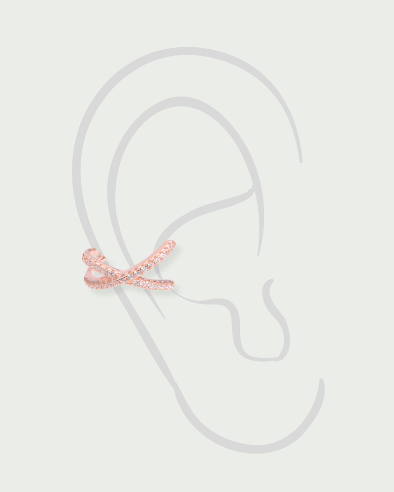 Earcuff Croisé Intemporel – Rose en argent 925 doré à l’or rose 18 carats, lignes entrelacées au design structuré et contemporain, finition lumineuse résistante à l’oxydation, format ajustable à clipser sans piercing, pensé pour illuminer l’oreille d’une touche douce et sophistiquée, à porter seul ou en accumulation.
