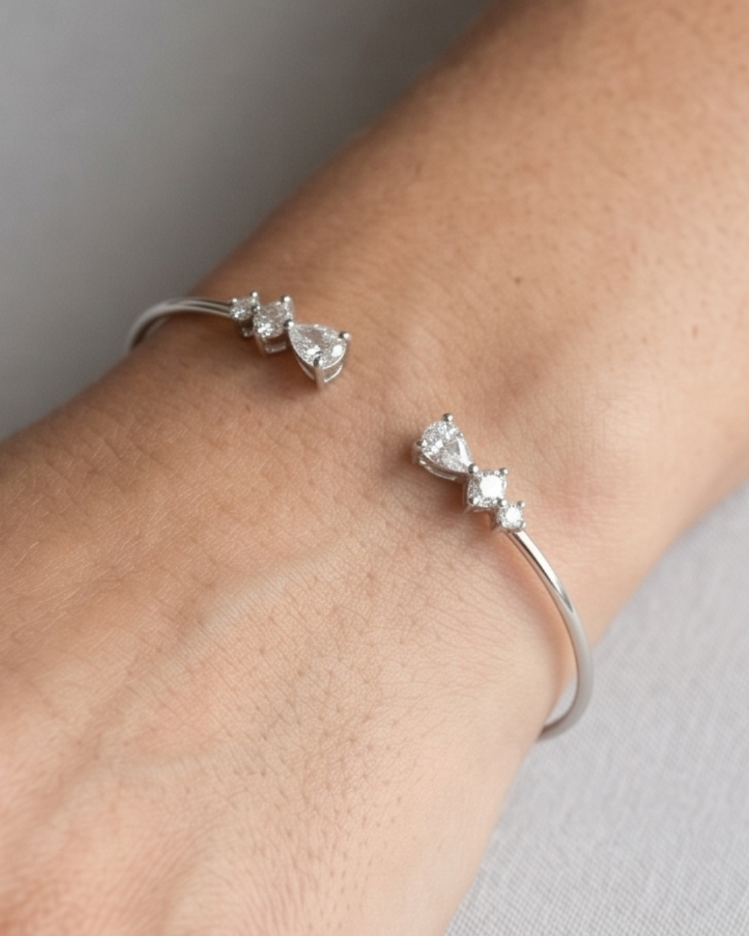 Jonc Opposite Éclat blanc GENA Jewelry en argent 925 rhodié, orné de zircons taille poire aux extrémités. porté