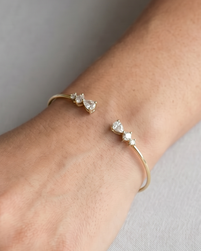 Jonc Opposite Éclat doré GENA Jewelry en argent 925 doré, orné de zircons taille poire aux extrémités. Porté