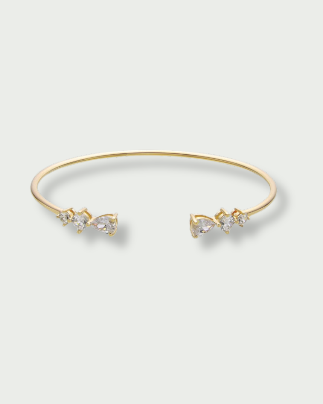 Jonc Opposite Éclat doré GENA Jewelry en argent 925 doré, orné de zircons taille poire aux extrémités.