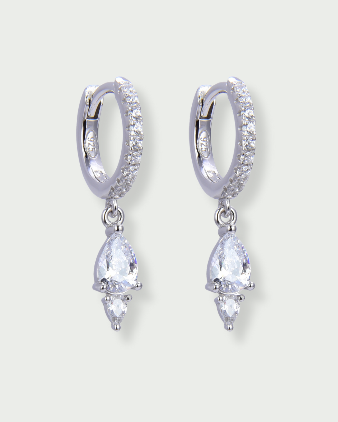 Mini-créoles Signature blanches en argent 925 rhodié ornées de zirconiums pavés et de pendentifs à double pierre taille poire, design délicat et lumineux qui capte la lumière et ajoute une touche raffinée à l’oreille.