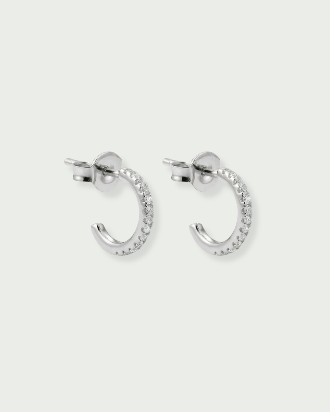 Boucles d’oreilles « Mini Créoles Intemporel » en argent 925 rhodié, diam. 12 mm, suite de mini‑zirconiums sur créole plate, finition polie brillante.