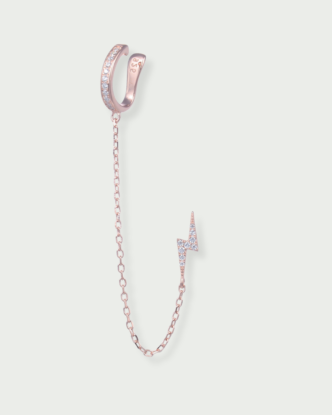 Monoboucle en argent 925 doré à l’or rose 18 carats, earcuff serti de zirconiums relié par une chaîne fine à une puce éclair pavée, finition polie brillante.