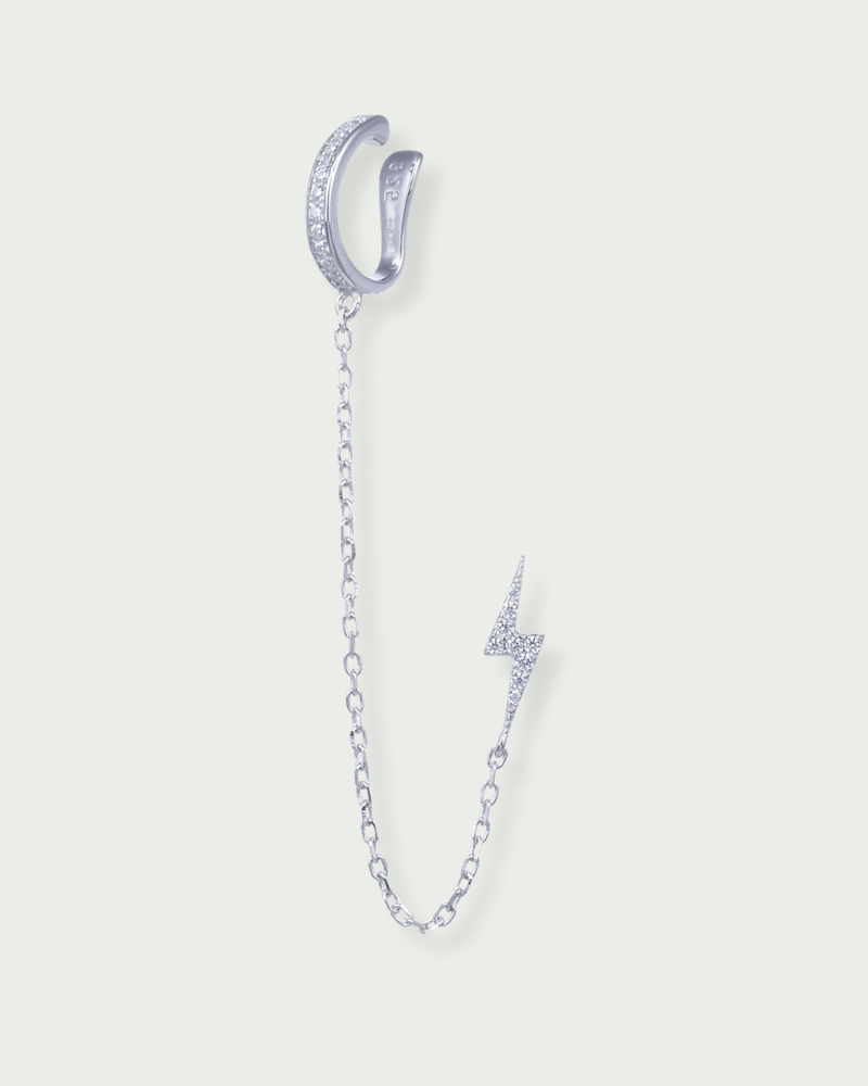Monoboucle en argent 925 rhodié, earcuff serti de zirconiums relié par une chaîne fine à une puce éclair pavée, finition polie brillante.