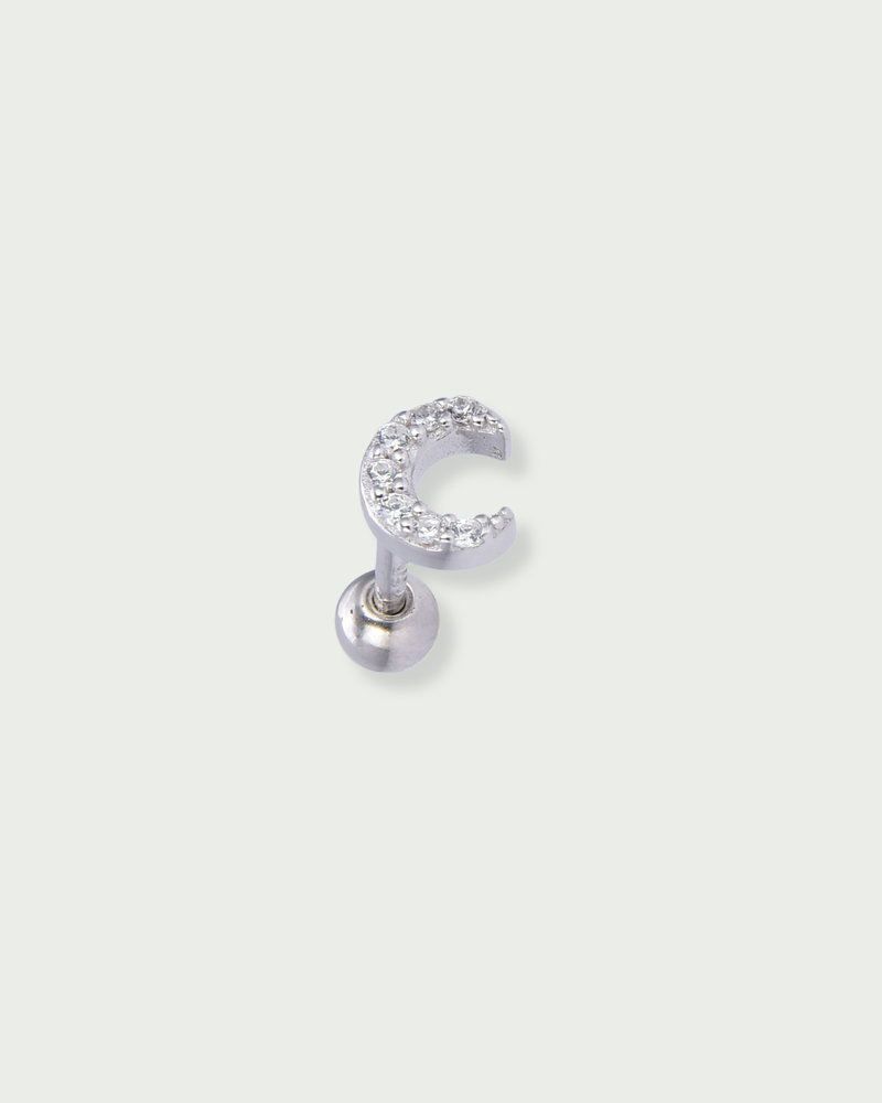 Piercing d’oreille en argent 925 millièmes rhodié, à la teinte blanche lumineuse, orné d’une petite lune délicatement pavée de zircons blancs. Sa silhouette céleste, fine et lumineuse, capte subtilement la lumière et illumine le lobe avec élégance