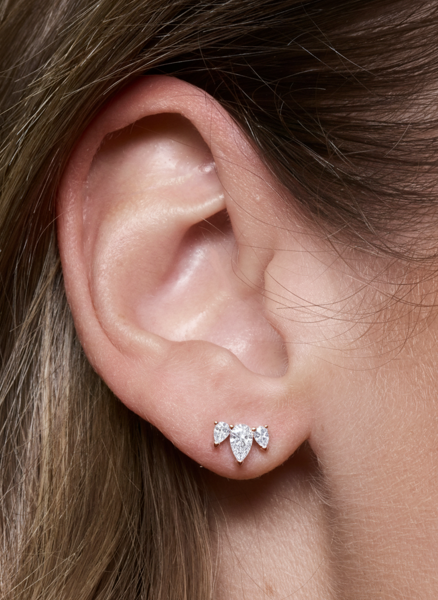 Puces d’oreilles Queen Pear Glow roses en argent 925 plaqué or rose 18 carats, ornées d’un trio de zirconiums taille poire formant une petite couronne scintillante, design délicat et lumineux qui sublime le lobe.