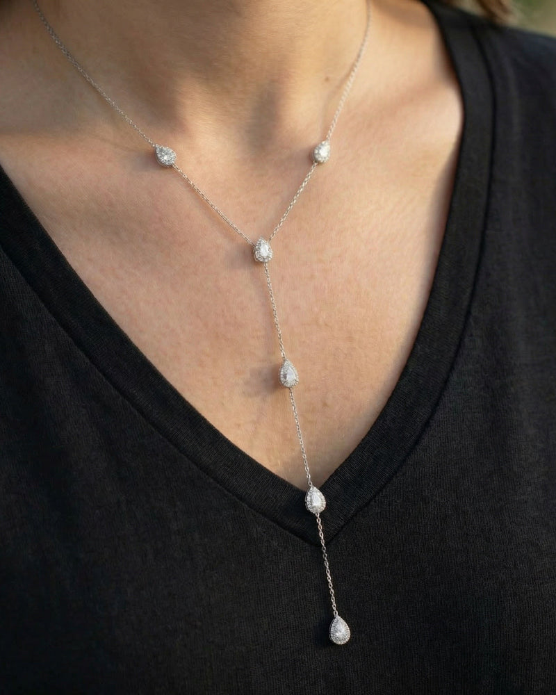 Ce sautoir délicat en argent 925 rhodié joue la carte de l’élégance aérienne. Les zircons blancs taille poire, sertis façon halo, s’enchaînent le long d’une chaîne fine et légère, créant une silhouette en cascade pleine de grâce.