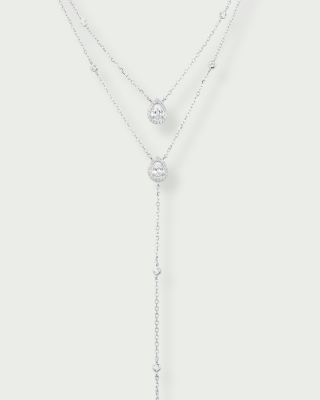 Sautoir « Double Infini Poire » en argent 925 rhodié, double chaîne élégante ornée de zirconiums taille poire, finition polie brillante.