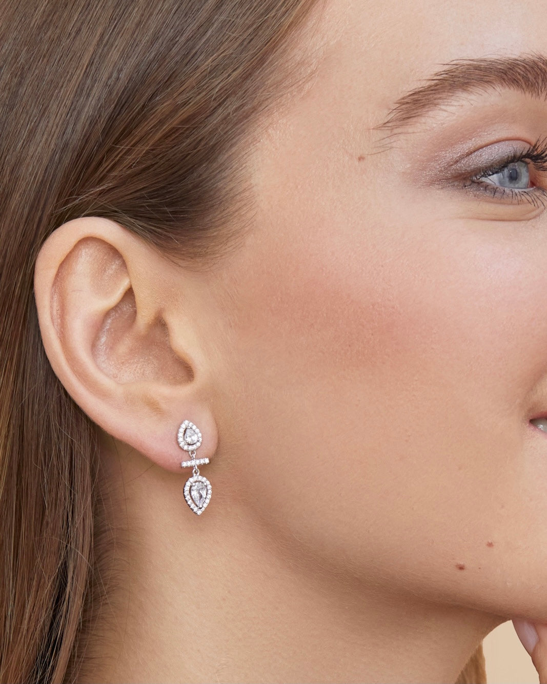 Boucles d’oreilles « Opposite Infini Poire » en argent 925 doré à l'or rose, deux zircons blancs taille poire montés en symétrie miroir, séparés par une petite barre sertie.