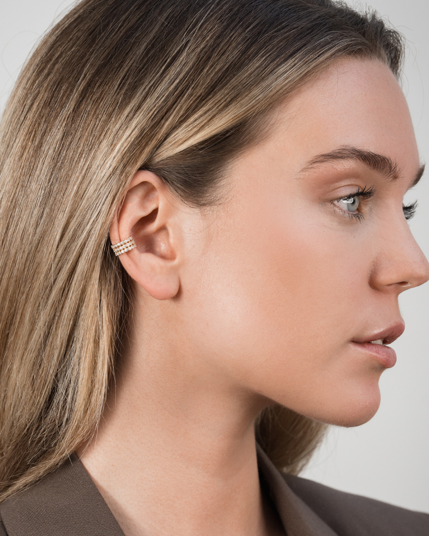Earcuff Pur Intemporel – Doré en argent 925 doré à l’or 18 carats, silhouette lisse et minimaliste sans serti pour une esthétique pure et contemporaine, finition lumineuse résistante à l’oxydation, design ajustable à clipser sans piercing, imaginé pour structurer l’oreille d’une touche solaire et sophistiquée, du quotidien aux compositions les plus audacieuses.
